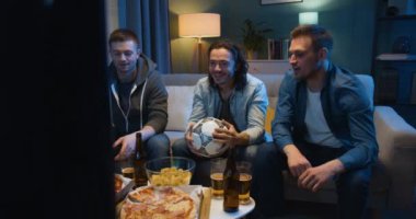 Pizza yiyip bira içen üç beyaz, neşeli en iyi arkadaş. Akşam evdeki kanepede TV karşısında oturan adamlar. Futbol taraftarları spor kanalında maç izliyor.