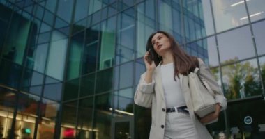 Beyaz, kendine güvenen bir kadın iş merkezindeki işini bırakıyor. Birinden gelen telefonu kabul etmek. Gününden ve hafta sonu için planlarından bahsediyor. Konuşurken gülümsüyor. Uzak iletişim.