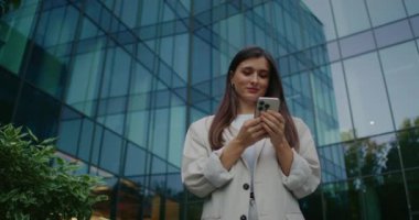 Kamera yavaş yavaş beyaz çekici bir kadına yaklaşıyor. Beyaz kostümlü bir kadın elinde akıllı telefon tutup mesaj ya da internette geziniyor. Telefonu indirip gülümserken doğrudan bakmak..