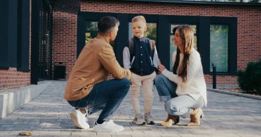 Annesi ve babası arasında duran sevimli küçük beyaz çocuk. Okuldaki endişeleri hakkında ailesiyle konuşuyor. Destekleyici anne ve baba cesaret verici sözler söylüyor. Dikkatle dinleyen çocuk.