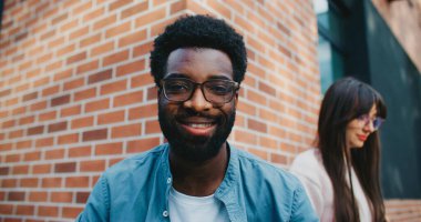 İnsanlar bir şey bekliyor. Çok ırklı öğrenciler dışarıda vakit geçiriyorlar. Yemek arasında alet edevat kullanmak. Akıllı telefon ekranına bakan bir adam. Dizüstü bilgisayarda yazan kız.