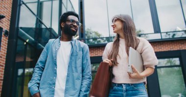 Modern binadan birlikte yürüyen iki çok ırklı arkadaş. Zor bir günün ardından üniversiteden ayrılmak. Dersler ya da yarınki planlar hakkında konuşurken gülümsüyordu. Fıkra anlatmak. Dostça sohbet..