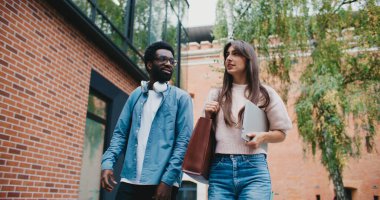 Çok ırklı şirin bir çift birlikte yürüyor. Üniversitede ya da üniversitede okuduktan sonra eve dönmek. Gülüyor. Birbirimize karşı olumlu duygular beslemek. Şefkat gösteriyorum. Hikayeler anlatıyor..