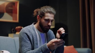 Erkek evde dinleniyor. Televizyon izlerken çığlık atan mutlu bir adam. Heyecanlı erkek futbol maçı izliyor. Favori takım için neşelenen bir adam. Gol attıktan sonra neşeli adam dans ediyor..