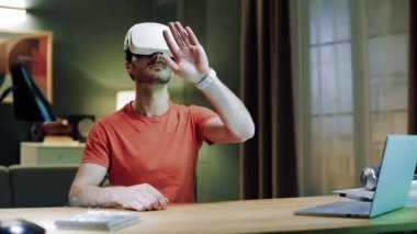 Sanal gerçeklik gözlüğü takan genç yaratıcı adam etrafı kolaçan ediyor. Oturma odasında oturan yakışıklı ve evde boş zaman geçirirken kulaklık takan adam. Teknoloji kavramı.