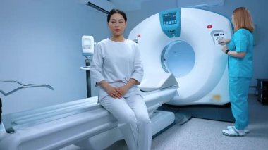 Teknik asistan manyetik rezonans tomografisi ve radyolojide MRI ile tarama hazırlıyor. Modern klinikte biyopsi için röntgen bekleyen hasta. Bilgisayar tomografi prosedürünün hazırlanması