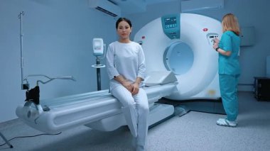 Tıbbi tesiste çağdaş ekipmanlarla manyetik rezonans görüntüleme. Hasta koltukları tarama masasında, çağdaş klinikte biyopsi için röntgen incelemesini bekliyor. Modern hastane.