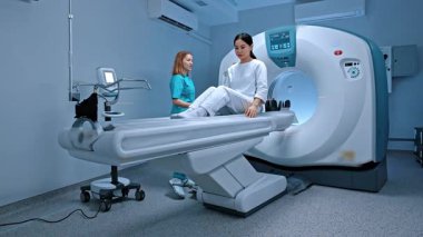 Profesyonel radyolog ve hasta bilgisayarlı tomografi odasında. Modern hastanede, uzman bir doktor, manyetik rezonans görüntüleme analizi için bilgisayarlı tomografi kapsülü kullanıyor..