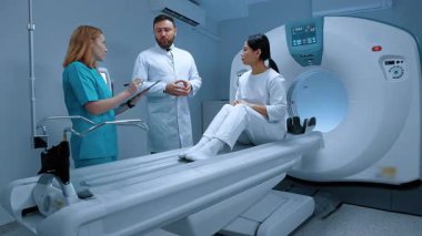 Beyaz önlüklü doktor MRI 'dan sonra hastaya tavsiye veriyor. Hasta MRI kapsülünde yatıyor. MRI dolabı. Modern ekipmanlar özel klinikte. Hemşire klasörü tutuyor ve not alıyor. MRI incelemesi.