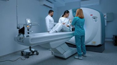 MRI tomografisi yapan doktor. Hasta muayene için hazırlanıyor. Özel klinikteki modern donanımlı dolap. Hemşire şef doktora yardım ediyor. MRI testi. Kısırlık prosedürü.