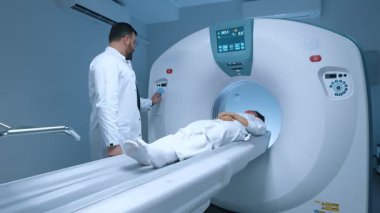 Yüksek teknoloji donanımlı bir tıp laboratuarı. Beyazlar içindeki hasta manyetik rezonans görüntülemesinden geçiyor. Pozitron emisyonu ve bilgisayarlı tomografi taraması. Tıp ve sağlık hizmetleri kavramı.