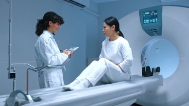 Pozitron emisyon tomografisi. Hasta mide, kas ağrısı, baş ağrısı, tomografi masasında oturmuş modern klinikte biyopsi röntgenini beklerken. MRI makinesi.