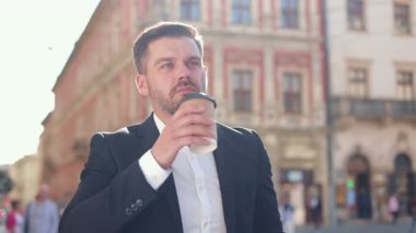 Sakallı genç bir adamın yavaşça şehirde yürüyüp etrafa bakındığı bir çekim. Kafkasyalı bir adamın kahve içmek için durup dışarıdaki binalara bakması..