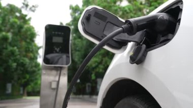 Elektrikli araba parkı ve şarj istasyonunun yanında şarj edilen enerji konseptinin sürdürülebilirliği. Çevresel koruma için yenilenebilir enerji tarafından kullanılan elektrikli araç.