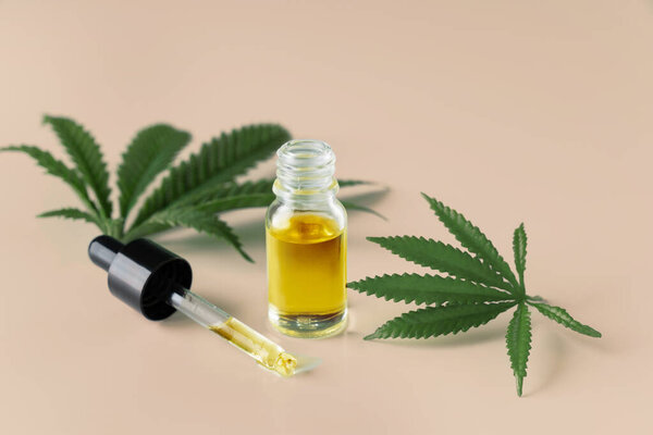 Лист конопли конопли конопли конопли с контейнером масла CBD с крышкой капельницы на белом фоне. Легализованная марихуана.