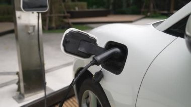 Elektrikli araba parkı ve şarj istasyonunun yanında şarj edilen enerji konseptinin sürdürülebilirliği. Çevresel koruma için yenilenebilir enerji tarafından kullanılan elektrikli araç.