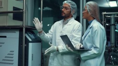 Two scientist in professional uniform working in curative laboratory for chemical and biomedical experiment