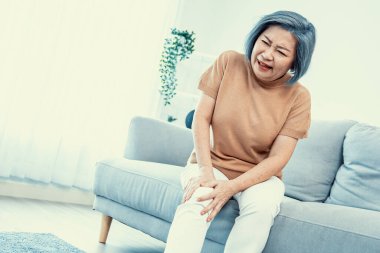 An agonizing elderly woman is experiencing chest pain. Medical attention, medical service for seniors.