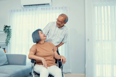 A contented senior couple and their in-home nurse. Elderly female in wheelchair with her young caregiver.