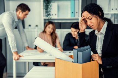 Depressed and disappointed employee packing her belongings after being fired for not being competent. Gossiped by her colleagues behind his back. Layoff due to economic depression.