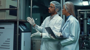 Two scientist in professional uniform working in laboratory for chemical and biomedical experiment