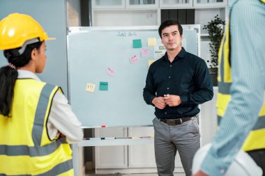 A team of investor and competent engineers brainstorming on the whiteboard to find new ideas and making plans. The idea of a team gather ideas together.