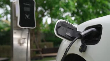 Elektrikli araba parkı ve şarj istasyonunun yanında şarj edilen enerji konseptinin sürdürülebilirliği. Çevresel koruma için yenilenebilir enerji tarafından kullanılan elektrikli araç.