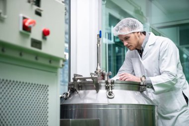 Bir bilim adamının portresi, eczacı laboratuarda bilimsel ekipman kullanarak kenevir yağı çıkarıyor. Alternatif tıbbi tedavi için esrar çıkarma kavramı