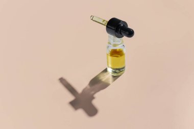 CBD yağı, beyaz arka planda izole edilmiş, damlatan kapaklı cam bir kapta yasal marihuana özütleme kavramını temsil ediyor..