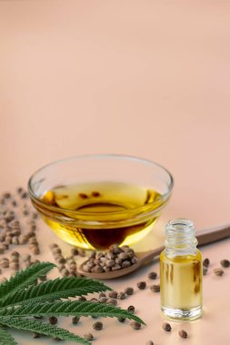 CBD yağı, cam kasede THC tintürü, damlalık kapaklı şişe ve boş arka planda kenevir yaprağı minimalizmle çevrili bir yığın kuru kenevir tohumu. Yasal marihuana konsepti.