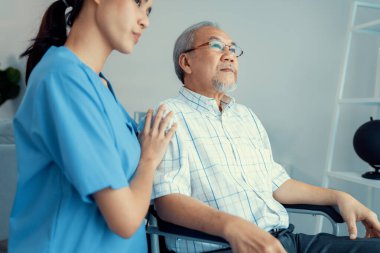 Caring nurse and a contented senior man in a wheel chair at home, nursing house. Medical for elderly senior, home care for pensioners.