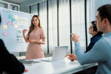 Competent office workers from various nationalities are debating, discussing and brainstorming in the meeting room. A group of employees is collaborating to achieve their business objectives.