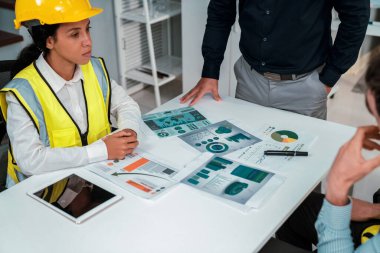 Engineers and competent employer discussing plans and blueprints together with tablet in the office. Concept of team contribution of ideas for engineering project.