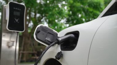 Elektrikli araba parkı ve şarj istasyonunun yanında şarj edilen enerji konseptinin sürdürülebilirliği. Çevresel koruma için yenilenebilir enerji tarafından kullanılan elektrikli araç.