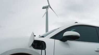 Çevreyi korumak için rüzgar türbininden yeşil ve yenilenebilir enerjiyle çalışan şarj istasyonunda şarj edilen gelişmiş gelecek enerji altyapısı konsepti.