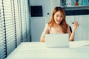 A young female employee receives a promotion, good news or finished her task and overjoyed for being a competent worker.