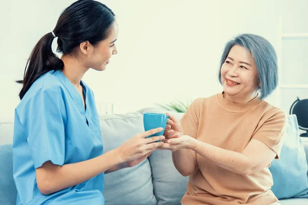 Female Care Taker Serving Her Contented Senior Patient Cup Coffee — Stockfoto