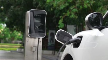 Elektrikli araba parkı ve şarj istasyonunun yanında şarj edilen enerji konseptinin sürdürülebilirliği. Çevresel koruma için yenilenebilir enerji tarafından kullanılan elektrikli araç.