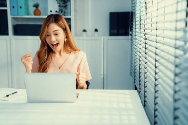 A young female employee receives a promotion, good news or finished her task and overjoyed for being a competent worker.