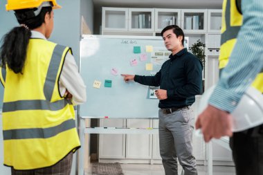 A team of investor and competent engineers brainstorming on the whiteboard to find new ideas and making plans. The idea of a team gather ideas together.