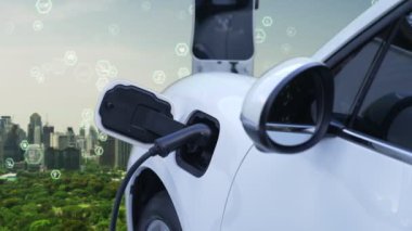 Gelişmiş yeşil şehir ESG sembolü elektrikli araçla arka plan, EV araba şarj noktasındaki enerji yenilenebilir enerji taşımacılığıyla çevre bilincini artırmak için şarj ediliyor.