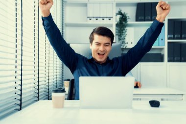 Young male employee receives a promotion, good news or finished his task and overjoyed for being a competent worker. Idea of promotion in career, reward for working hard worker.