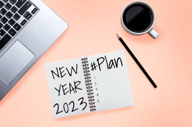 2023 Mutlu Yeni Yıl Kararları Hedef Listesi ve Planları Ayarlama - Yeni yıl hedefleri ve kararları planlama hakkında not defteriyle birlikte iş yeri masası. Değişim ve kararlılık kavramı.