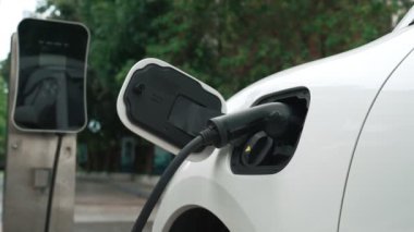 Elektrikli araba parkı ve şarj istasyonunun yanında şarj edilen enerji konseptinin sürdürülebilirliği. Çevresel koruma için yenilenebilir enerji tarafından kullanılan elektrikli araç.
