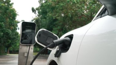 Elektrikli araba parkı ve şarj istasyonunun yanında şarj edilen enerji konseptinin sürdürülebilirliği. Çevresel koruma için yenilenebilir enerji tarafından kullanılan elektrikli araç.