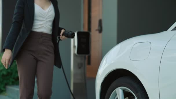 Progressieve Vrouw Installeert Een Laadstation Stekker Haar Elektrische Auto Thuis — Stockvideo