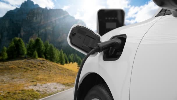 采用发电机驱动的可持续能源汽车动力 为具有山地背景的充电站充电蓄电池提供先进的旅行理念 大自然中的电动车是清洁环境的象征 — 图库视频影像