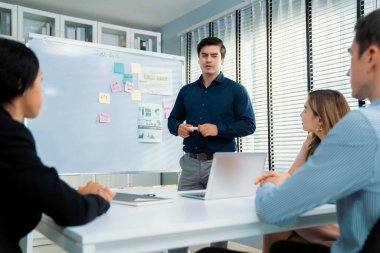 Competent office workers from various nationalities are debating, discussing and brainstorming in the meeting room. A group of employees is collaborating to achieve their business objectives.