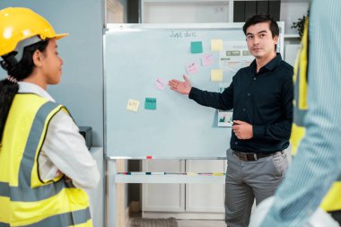 Entrepreneur brainstorming ideas with his competent engineers in the office. Architectural investors and engineers working on an upcoming project in a fun and friendly environment.