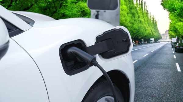 Прогрессивный зеленый город ESG зеленые деревья фон с электрическим транспортным средством, EV автомобиль подзарядки энергии в точке зарядки для повышения экологической осведомленности с использованием возобновляемых источников энергии питание транспорта.